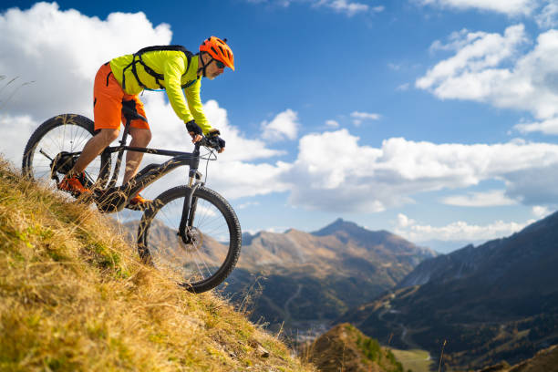 istock one mountain biker cycling down steep pasture high up in mountains 1124750233