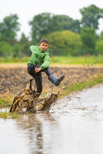 istock aggressive boy splashing dirty water on rainy day 1124750511