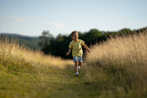 istock happy little boy running in rural landscape 1124752381