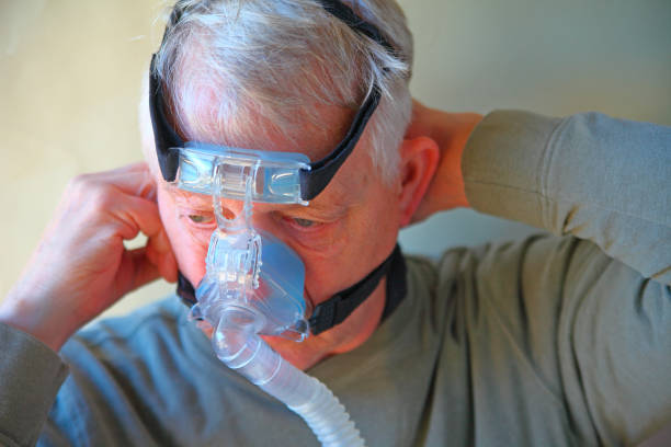 Cтоковое фото Человек регулирует головные уборы CPAP