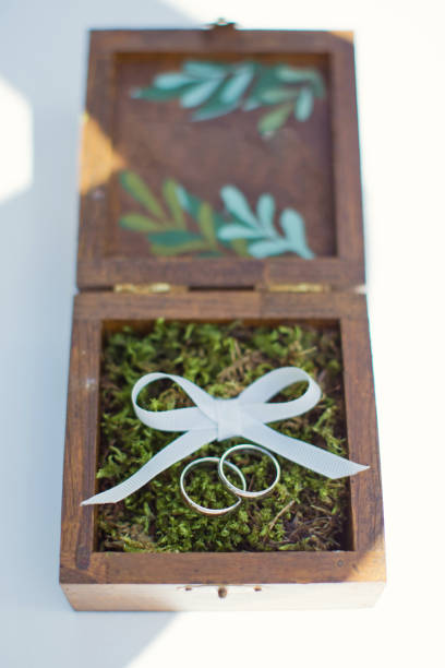 istock Wedding rings on moss in wooden box 1124753487