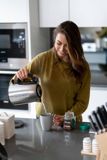 istock Woman making a cup of coffee at home 1124755484
