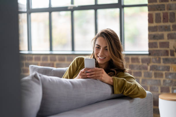 istock Young woman at home texting on her cell phone 1124755493