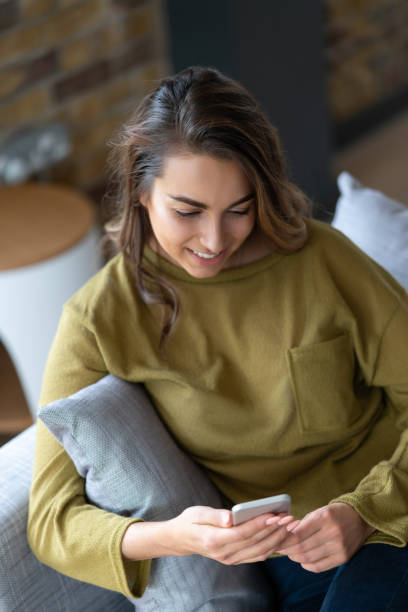 istock Beautiful woman at home using app on her cell phone 1124755495