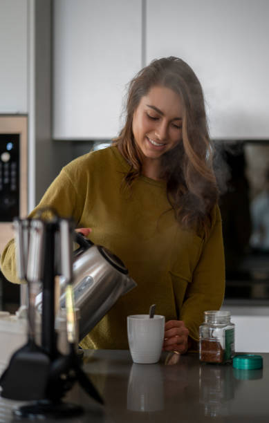 istock Woman making a cup of coffee at home 1124755497