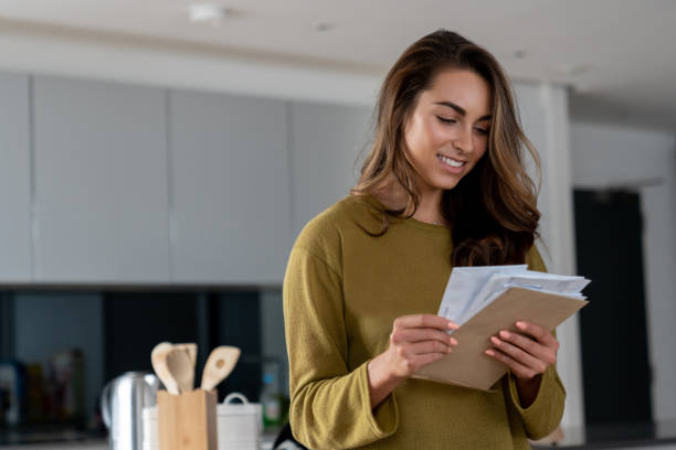 istock Happy woman at home checking her mail 1124755619