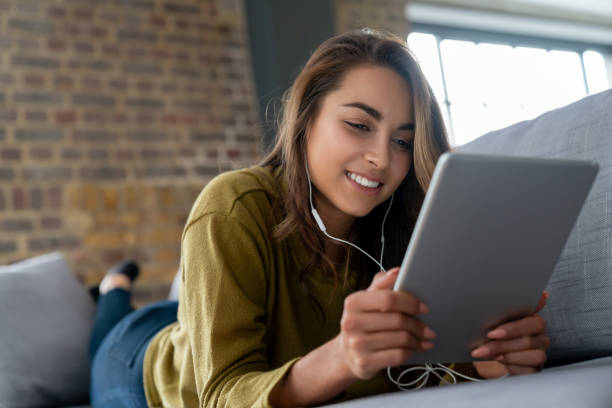istock Happy woman watching videos on a tablet computer at home 1124755639