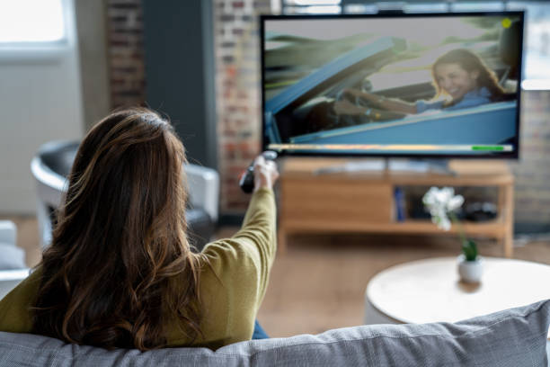 mujer relajante en casa viendo la televisión - cambiar de canal fotografías e imágenes de stock