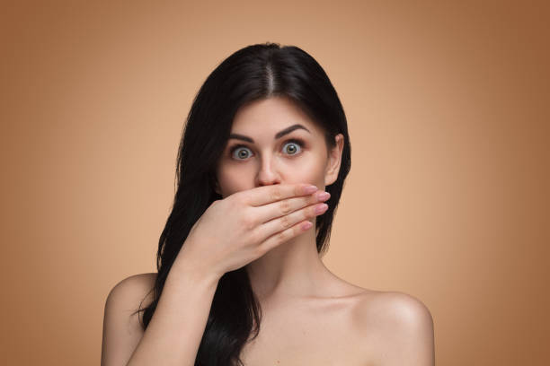 istock Playful model covering mouth with hand 1124757892