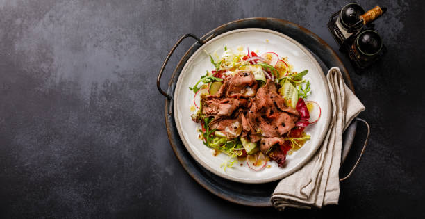 istock Salad with Roast Beef and vegetables on dark background copy space 1124757972