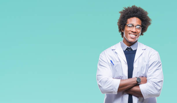 médecin américain afro homme de scientifique sur le visage heureux isolé fond sourire avec les bras croisés en regardant la caméra. personne séropositive. - scientist male young adult doctor photos et images de collection