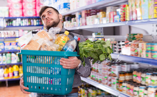 istock Adult guy standing with full shopping basket 1124767515
