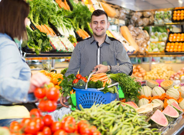istock Glad seller helping customer to buy vegetables 1124767609