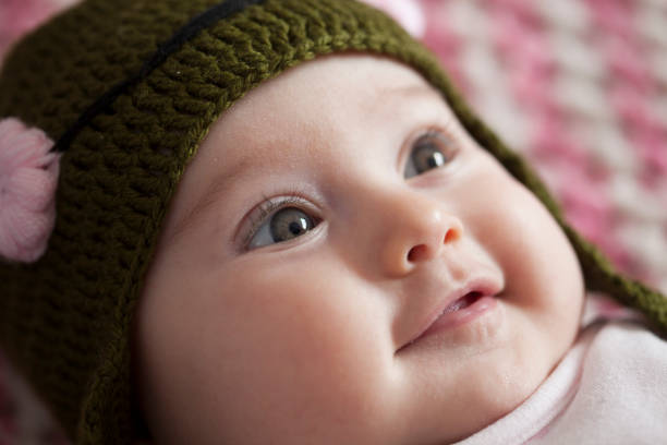 Portrait of a beautiful baby girl with a pink band on her head lying on the sofa