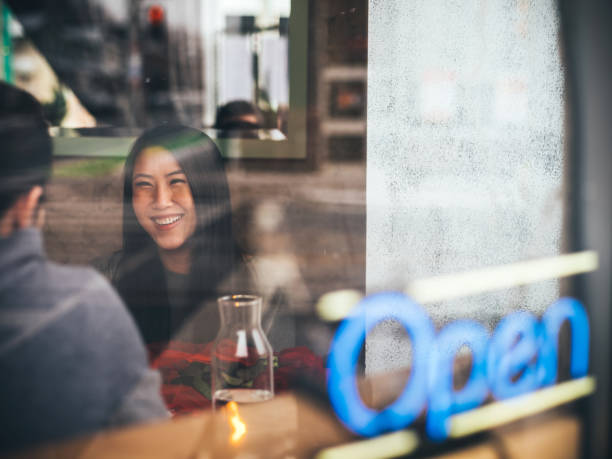 Business people during the coffee break near the window. View through the window with city reflection