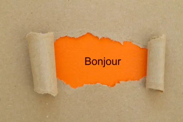 French Bonjour (hello) word written under torn paper.