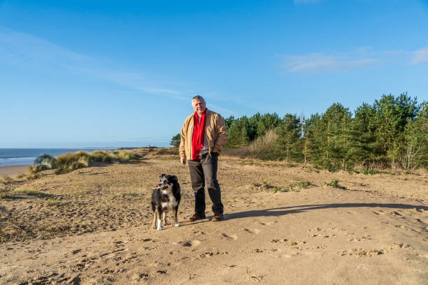 istock Senior Caucasian man on beach with dog 1124790417