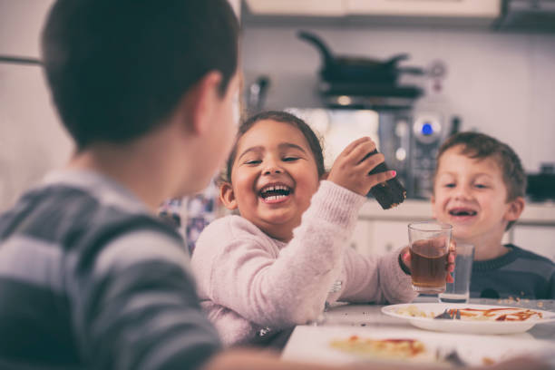istock Children at the kitchen table, talking, laughing eating, drinking. 1124796786