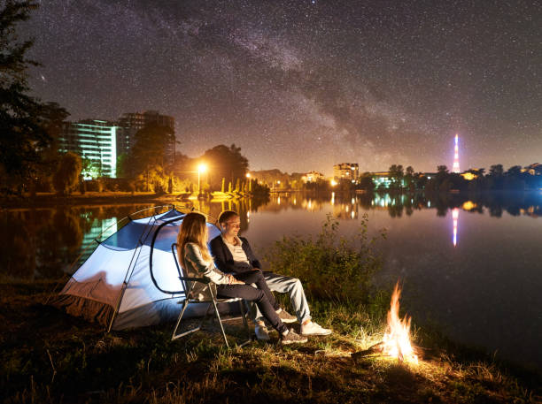 istock Man and woman having a rest on shore under night sky 1124801530
