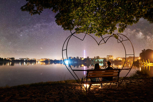 istock Man and woman having a rest on shore under night sky 1124801532