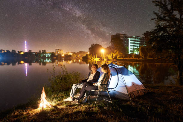 istock Man and woman having a rest on shore under night sky 1124801535