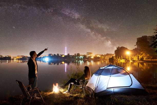 istock Man and woman having a rest on shore under night sky 1124801539