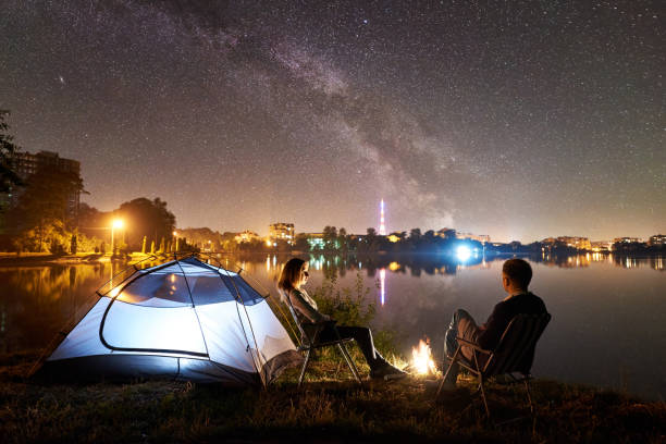 istock Man and woman having a rest on shore under night sky 1124801550