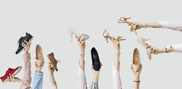 istock Hands holding different shoes on isolated background 1124805127
