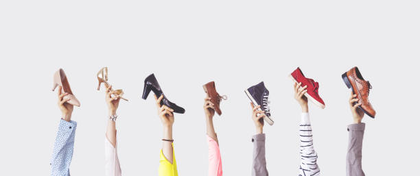 istock Hands holding different shoes on isolated background 1124805693