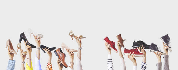 istock Hands holding different shoes on isolated background 1124805696