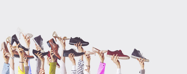 istock Hands holding different shoes on isolated background 1124806261