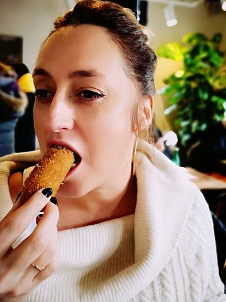 istock woman eating a shrimp croquette 1124807367