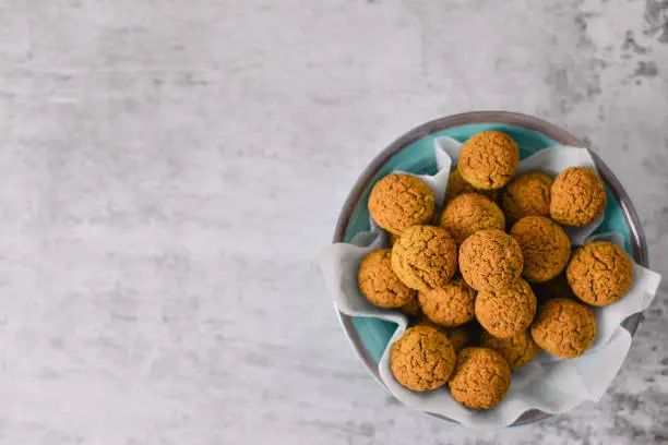 Photo of Baked chickpea falafel balls on blue plate on grey background , healthy and vegan food with tahini deep and hot pepper , traditional Mediterranean , top view , flat lay with copy space