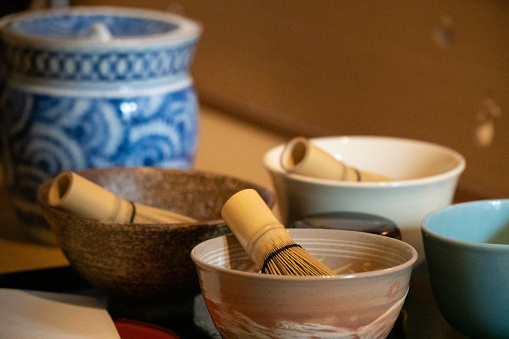 Traditional Japanese tea ceremony bowls and whisks on Japanese tatami mats - Kyoto, Japan.