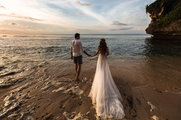istock Young couple running along the water on the beach 1124824449