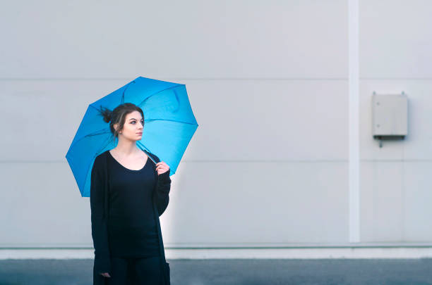 Woman cheerful summer girl standing under colorful rainbow umbrella, Attractive female long hair model. Forecasting and weather season concept