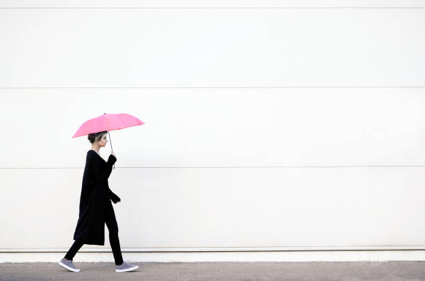 giovane donna che cammina con l'ombrello rosa - beautiful caucasian teenager running foto e immagini stock