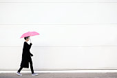 Young woman walking with pink umbrella