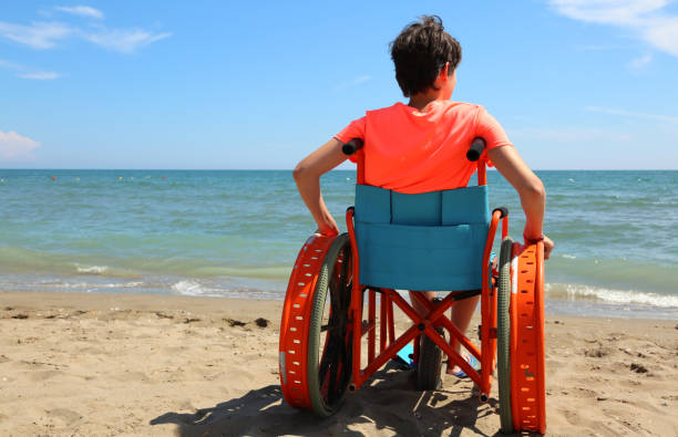 istock young boy on the wheelchair on the beach 1124834189