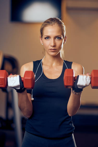 istock Beautiful blonde girl lifting dumbbells. 1124837206