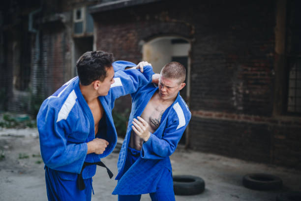 istock Judokas in blue kimonos fighting outdoors 1124853794