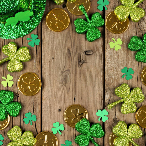 istock St Patricks Day square frame with shamrocks, gold coins & leprechaun hat over rustic wood 1124856530