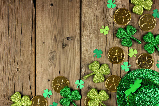 istock St Patricks Day corner border with shamrocks, gold coins & leprechaun hat over rustic wood 1124856781