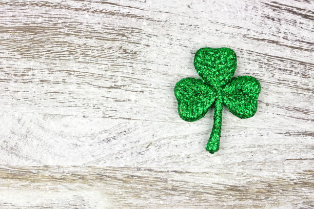 istock St Patricks Day glittery shamrock over rustic white wood 1124857345