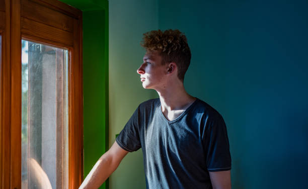 istock Teenage Boy Looking Through the Window 1124860061