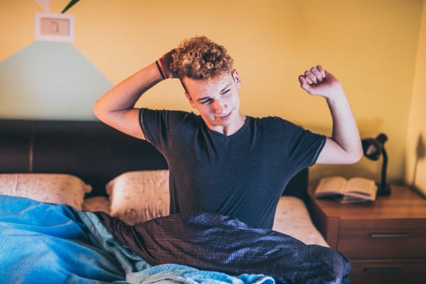Teenage Boy Having a Morning Stretch in his Bed