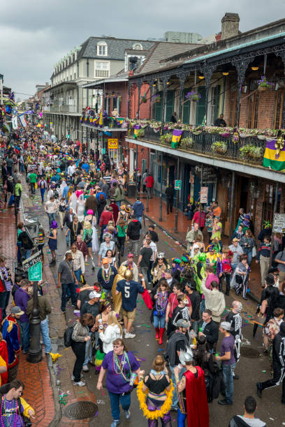 High angle view of a crowd of people, many in costume, walking on Bourbon Street in the French Quarter of New Orleans during Mardis Gras