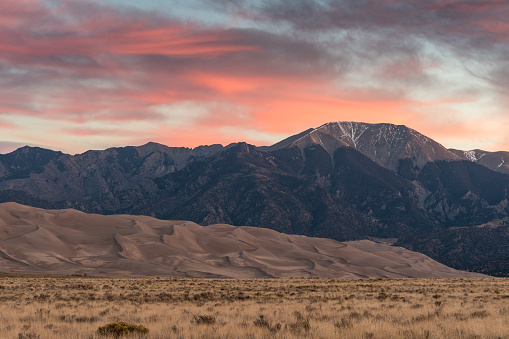 Colorful Sunrise at Great Sand Dunes National Park and Preserve with pink skies and mountains in the background