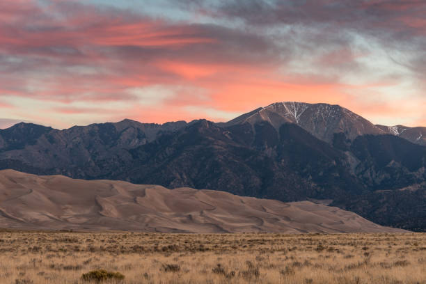 Colorful Sunrise at Great Sand Dunes National Park and Preserve Colorful Sunrise at Great Sand Dunes National Park and Preserve with pink skies and mountains in the background great sand dunes national park stock pictures, royalty-free photos & images