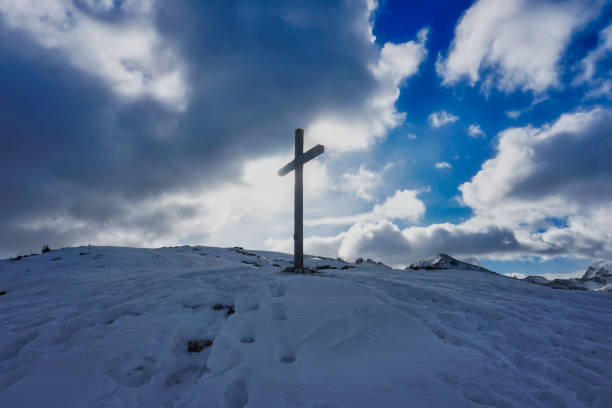 istock Christian Cross silhouette snow mountain clouds sky 1124863349